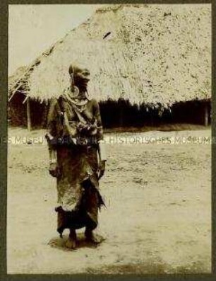 Ältere Massai-Frau vor einer Hütte