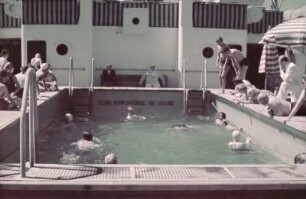 Blick aufs Schiffsdeck der MS Milwaukee. Passagiere beim Baden im Pool