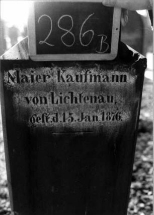 Grabstein 286 (Index: 100112044) Material: Sandstein Zustand: leicht verwittert Maße HxBxT: 137x45x20 cm Beschreibung: Stele, profilierter Sockel, Abschluß: Sonderform, rechteckiges Schriftfeld eingetieft Symbolik: Blüte: Grabstein 286B