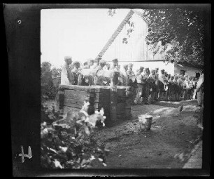 "Appell in litauischem Dorf" (seitliche Distanzaufnahme)