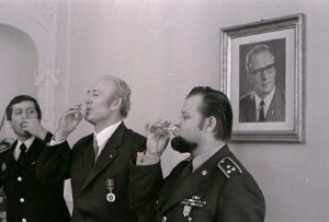 Deutsche und tschechische Funktionäre trinken im Rat des Kreises Erfurt-Land Schnaps + Erich Honecker sieht zu, ca. 1980