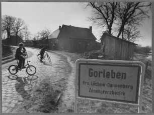 Ortsschild von Gorleben, auf der Straße Kinder mit Fahrrädern