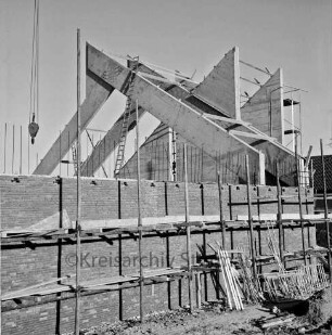 Kirche in Bau: Rohbau mit Gerüst: Aufsetzen der Dachbinder aus Holz: Haken von Baukran, Leitern