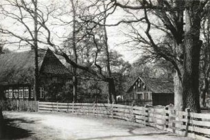 Walsrode-Krelingen. Bauernhof. Bauernhaus (Niedersächsisches Hallenhaus) und Nebengebäude. Straßenansicht mit Einfriedung
