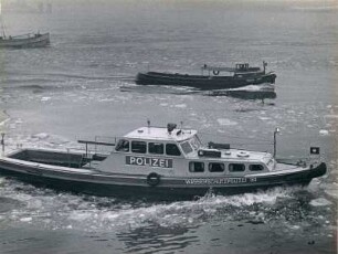 Hamburg. Winter 1962. Ein Boot der Wasserschutzpolizei im zufrierenden Hafen. Im Hintergrund eine Barkasse