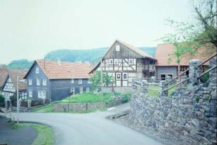 Untere Dorfstraße mit Teil der Kirchenmauer; alle Gebäude sind denkmalgeschützt