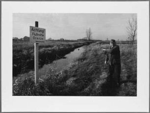 Otto Porath am Fluss mit Schild: Achtung! Flußmitte Grenze, Schnackenburg