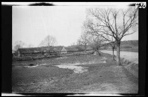 Rossienie (=Raseiniai, Litauen): reetgedeckte Gebäude und Weiher ("Einfall in Kurland: russisches Dorf. 27.4.1915")