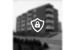 Ehmkenberg: Wohnblock der Gemeinnützigen Wohnstättengenossenschaft eG Bad Oldesloe: davor Grünstreifen, Parkplatz mit Pkw: hinten rechts Rohbau eines Hochhauses