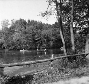 Kupfermühle: Kupfermühlenteich: vorn Holzgeländer: rechts Bäume: hinten Ruderboote mit Ausflüglern: dahinter Wald