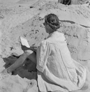Frau zeichnet am Strand