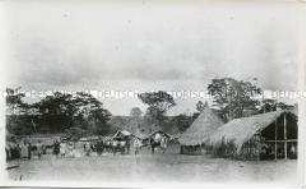 Zwei Kolonialbeamte in einem Dorf im Kameruner Grasland