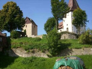 Ansicht von Osten mit Kirche über Kirchhofmauer (Wehrgang im 18 Jh abgetragen) sowie Torturm im Süden - hangseitig unter der Kirchhofmauer Reste einer Zwingermauer