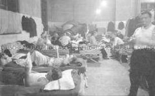 Selbstversenkung des Hochseepassagierdampfers "Columbus" am 19. Dezember 1939, Besatzungsangehörige im Internierungslager auf Ellis Island, in einfachen Feldbetten liegend, Zeitung lesend