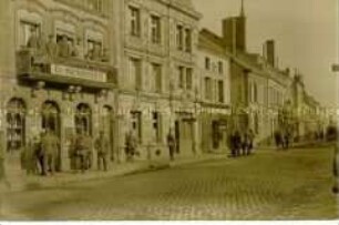 Straße in einer französischen Stadt, mit Soldaten vor einer Marketenderei und Weinstube