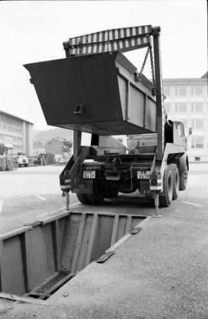 Freiburg: Parkplatz Stefan-Meier-Straße, Umsetzten des Müllbehälters durch Transportwagen