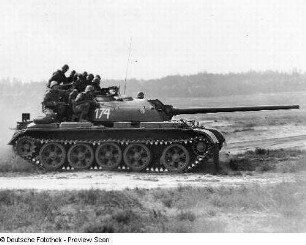 Deutschland . Nationale Volksarmee - Landstreitkräfte. Kampfpanzer mit aufgesessenen Schützen in Fahrt in offenem Gelände