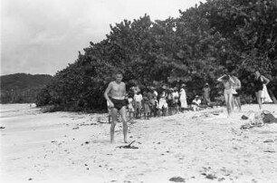 Reisefotos Karibik. Trinidad. Gruppe junger Muschelverkäufer und europäische Touristen in Badebekleidung
