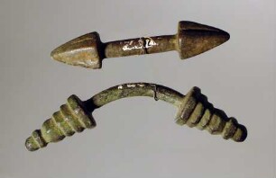 Zwei stangenförmige, knopfartig auslaufende Geräte (Mantelschließen)