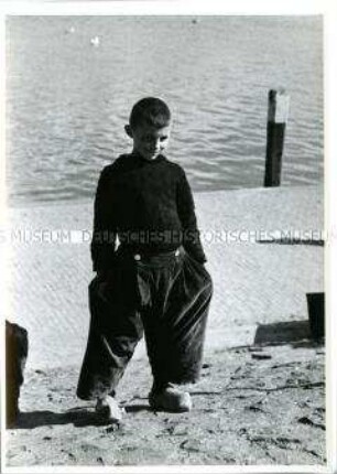 Holland, Volendam, Junge in tradioneller Kleidung am Hafen