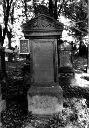Grabstein 327 (Index: 100111964) Material: Sandstein Zustand: stark verwittert mit Textverlust Maße HxBxT: 180x70x46 cm Beschreibung: Stele, profilierter Sockel, überragender Giebel mit Mittelakroter, rechteckiges Schriftfeld eingetieft Symbolik: Ranken: Grabstein 327