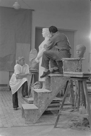 Studenten der Bildhauerklasse von Walter Arnold beim Modellieren der Gips-Statue einer stehenden Frau mit verschränkten Händen (1960/1962)