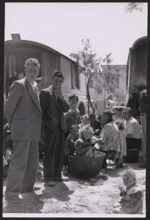 Kinderreiche Roma-Familie zwischen zwei Pferdewägen