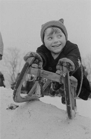 Leipzig, Johannapark. Kinder beim Ski- und Schlittenfahren, Junge auf einem Schlitten liegen kurz vor der Abfahrt im Johannapark Leipzig
