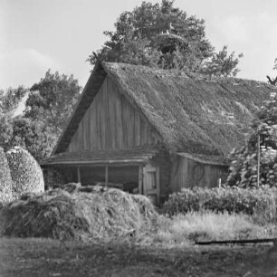 Blick auf ein mit Strohgedecktes Blockhaus mit Storchennest. : Wid na ze słomu pokrytu kładźitu chěžu z baćonjacym hnězdom.