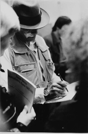 Der Künstler Joseph Beuys beim Signieren