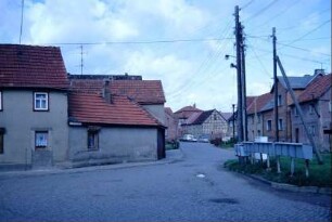 Dorfplatz mit Straßeneinmündungen, Häuser, Postverteilungsanlage