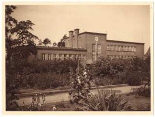 Waldschule, Hindenburg: Gartenanlage mit Bepflanzung (Malven) und Schulgebäude im Hintergrund