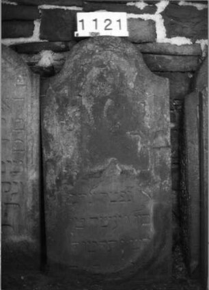 Grabstein 1121 (Index: 99630624) Material: Sandstein Zustand: oben völlig abgeblättert, Textverlust Maße HxBxT: 113x56x11 cm Beschreibung: Stele mit Konvexbogenabschluß: Grabstein 1121