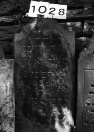 Grabstein 1028 (Index: 99630531) Material: Sandstein Zustand: abgeblättert, verwittert, Textverlust Maße HxBxT: 74x36x6 cm Beschreibung: Stele mit eingezogenem Segmentbogenabschluß: Grabstein 1028 (1)