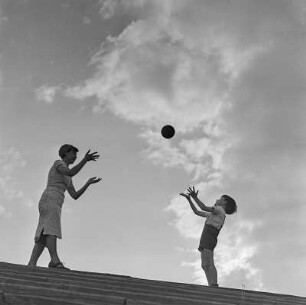 Elisabeth Gremmler und ihr Kind spielen Ball auf einer Treppe