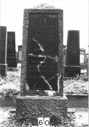 Grabstein 60 (Index: 99808417) Material: Granit, schwarze Marmorplatte Zustand: Platte gesprungen Maße HxBxT: 138x57x29 cm Beschreibung: Obelisk, Sockel, Schriftplatte: Grabstein 60