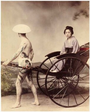 Tätowierter Mann mit Geisha in Rikscha