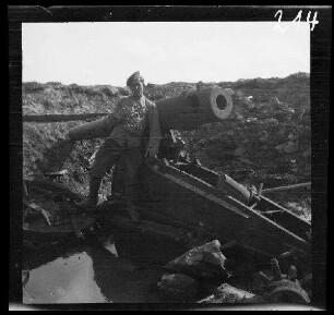 bei Kowno (=Kaunas, Litauen): "von den Russen auf dem Rückzug aus Kowno (=Kaunas, Litauen) zerstörtes 15 cm-Geschütz", davor ein Soldat mit einem Zweig in der Hand