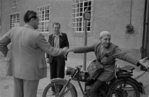 Jahna. Drei Männer im Gespräch (einer auf einem Motorrad sitzend)
