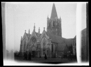 Comines (Dep. Nord, Frankreich): Kirche [Saint-Chrysole], im Vordergrund der Kirchplatz mit Passanten ("Kathedrale in Comines")