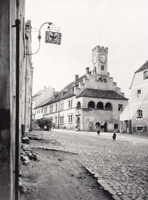 Nabburg, Straßenansicht mit Ausleger mit Doppeladler. Blick zum Rathaus mit Staffelgiebel und Uhrturm. An der Fassade ein Hinweisschild "Zum goldenen Löwen"