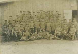 Robert Eugen Orth, Vizefeldwebel, bei einem Offiziersanwärterkurs mit fünfzig Kameraden vor Holzwand eines Gebäudes
