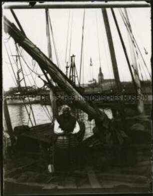 Frau in Tracht an Bord eines Schiffes