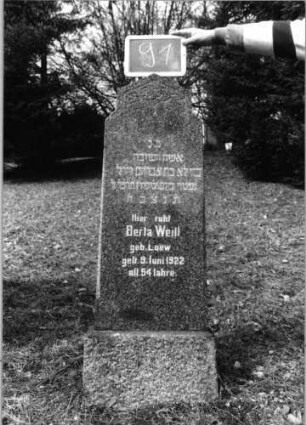 Grabstein 91 (Index: 100090246) Material: Granit Zustand: gut Maße HxBxT: 130x39x15 cm Beschreibung: konische Stele, Sockel, rund eingezogener erhöhter giebelartiger Abschluß Symbolik: geometrisches Muster im Abschluß: Grabstein 91