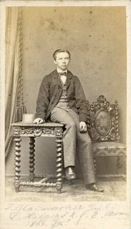 Fotografie eines auf einem Tisch sitzenden sehr jungen Herren