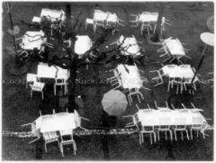 Leere Terrasse eines Cafés mit Regenschirm