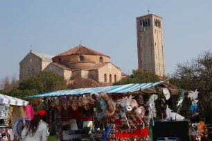 Venedig - Auf der Insel Torcello : Souvenirstand vor den Kirchen Santa Maria Assunata (mit großem Glockenturm) und San Fosca (davor) auf der kleinen Insel Torcello in der Lagune von Venedig, aufgenommen 2007