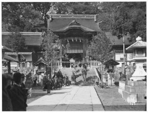 Nagasaki. Erwachsene und Kinder in traditioneller Kleidung vor dem Eingang des Asura-Tempels
