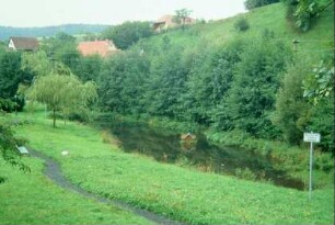 Teich mit kleiner Grünanlage und Sitzbänken am Ortsaugang nach Keulenrod