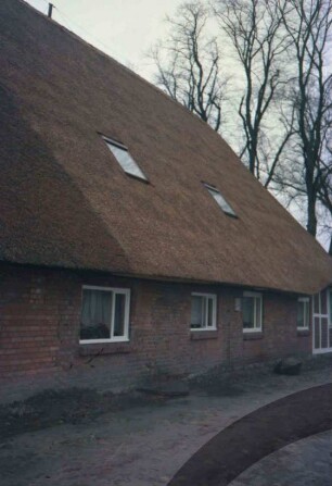 Papierholz 1: Gaststätte Zur Hahnheide: giebelständiges Bauernhaus mit Reetdach: Traufseite aus Backstein, rechts Fachwerk